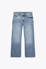 Pantalón de jean celeste de tiro bajo, corte flare, cropped y cinco bolsillos.