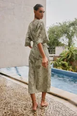 Vestido midi color verde oliva con estampado floral, escote en V, manga corta amplia y detalle drapeado en la cintura.