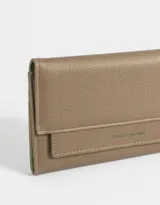 Billetera color marrón de cuerina con doble solapa y tag en relieve.