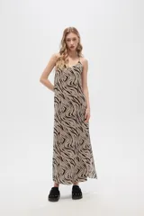 Vestido largo con estampado animal print en tonos beige y negro, breteles finos y corte holgado.