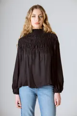 Blusa negra de cupro y viscosa, con cuello alto fruncido y mangas largas abullonadas.