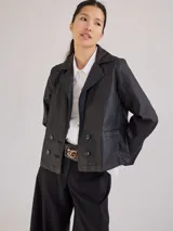 Campera corta negra simil cuero con cuello clásico, doble botonadura y bolsillos frontales.