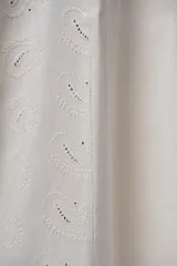 Pantalón palazzo color beige con bordados calados en forma de paisley en los laterales.