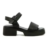 Sandalias negras de cuero sintético con plataforma y taco cuadrado. Tira ancha sobre el empeine con diseño tejido y pulsera al tobillo con hebilla.