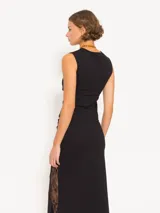 Top negro de punto con calce al cuerpo y cuello redondo. Presenta recortes laterales de encaje y logo JCH bordado en el lateral.