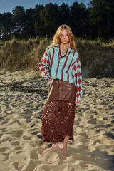 Camisa celeste con rayas verticales rojas y mangas con rombos rojos.