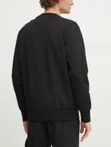 Buzo negro de cuello redondo, marca Calvin Klein Jeans. Confeccionado en tejido interlock suave de mezcla de algodón, poliéster y elastano. Presenta puños y dobladillo con punto canalé y monograma de Calvin Klein bordado tonal en el pecho.
