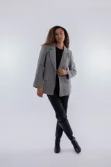 Blazer gris con diseño clásico, corte recto y solapas amplias, de manga larga.