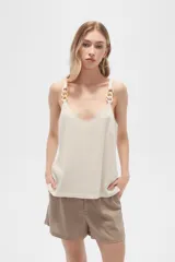 Musculosa color crema de bretel fino con apliques de cadena en los breteles y escote en V.