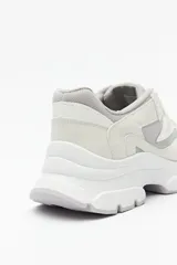 Zapatillas deportivas color gris claro con recortes en gamuza y textil transpirable, cordones a tono y plataforma de 5cm de alto.