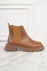 Bota Chelsea de cuero color marrón, con elásticos laterales y suela track.