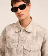 Campera masculina de sarga con estampa abstracta, corte boxy, cuello inglés, manga larga con puños abotonados, cierre frontal abotonado y bolsillos delanteros.