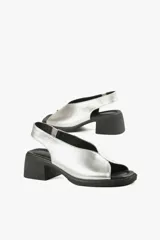 Sandalias plateadas de cuero con diseño slingback, puntera abierta y tacón cuadrado bajo color negro.