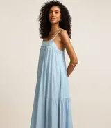 Vestido largo celeste de jeans con breteles finos, escote cuadrado, lazo en la espalda y abertura en la parte inferior.