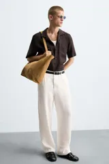 Bolso tipo shopper color marrón claro, fabricado en piel serraje. Cuenta con dos asas de mano y un bolsillo interior con cierre de cremallera.