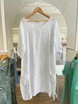Vestido celeste de lino, corte oversize, con mangas cortas y bolsillos laterales.