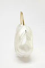 Bolso de mano asimétrico con efecto perlado y asa rígida dorada. Incluye asa de cadena extraíble y cierre magnético.