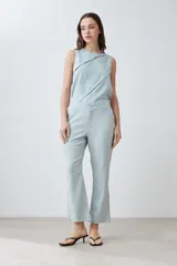 Pantalón celeste de lino, corte recto, con efecto desflecado en el ruedo.