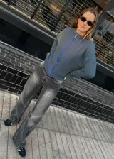 Campera tejida con textura vanizada a rayas verticales en color lila y negro, con cierre frontal y cuello alto.