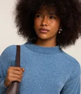 Buzo suéter de chenille color blanco, con cuello alto y rib en puños, cuello y bajo.