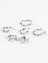 Set de tres pares de aros dorados con diferentes diseños: aros tipo argolla, aros cuadrados y aros hexagonales con incrustaciones de strass.