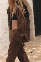 Pantalón marrón de corte ancho, con cintura elástica y bolsillos laterales.