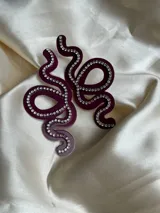 Aros colgantes con forma de serpiente azul contorneada con strass plateado.