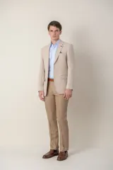 Pantalón de vestir azul marino, de corte recto, confeccionado en lino. Se ajusta a la cintura con cinturón de cuero marrón.