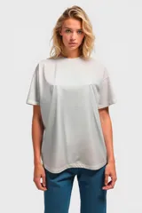 Remera color beige de corte holgado y mangas cortas.