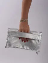 Sobre de mano color crema, con cierre de cremallera y tira de cuero para sujetar a la muñeca.