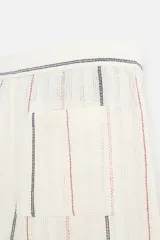 Bermuda regular fit color crudo con rayas verticales en azul y rojo, confeccionada en tejido con mezcla de algodón. Cintura elástica ajustable con cordón interior. Bolsillos laterales y detalle de bolsillo trasero de plastrón.