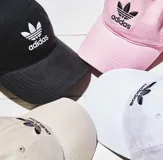 Gorra negra Adidas Originals con logo bordado en blanco en el frente.