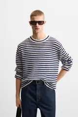 Jersey de punto con rayas horizontales en azul marino y blanco, cuello redondo y manga larga.