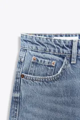 Pantalón de jean celeste de corte amplio, con tiro medio, cinco bolsillos y costuras torcidas.