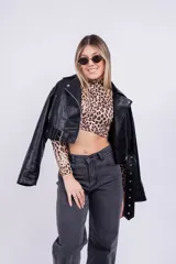 Campera de cuero sintético negra, con cierre cruzado, cuello con solapas y cinturón ajustable.