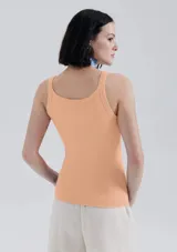 Musculosa slim color ocre, de tela acanalada con cuello redondo y sisas anchas.