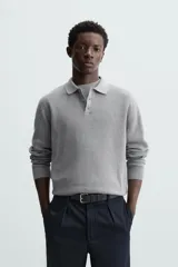 Polo marrón de corte relaxed fit, tejido en punto de algodón. Tiene cuello solapa con cierre frontal de botonadura, manga larga y acabados en rib.