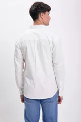 Camisa blanca de manga larga con cuello abotonado y bolsillo en el pecho.