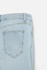 Pantalón de jean negro con corte skinny fit, cinco bolsillos, lavado con efecto roto y cierre frontal con cremallera y botón.