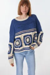 Sweater azul con cuello redondo y diseño de cuadrados de crochet en la parte inferior.