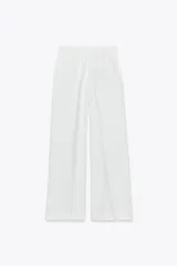 Pantalón blanco de tiro alto con pinzas delanteras, bolsillos laterales y cintura elástica en la parte trasera.