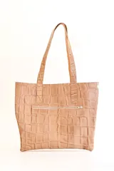 Cartera tipo tote bag de cuero color beige con textura tipo piel de cocodrilo. Tiene doble asa de hombro y un bolsillo externo con cierre.