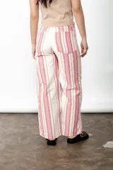 Pantalón wide leg de lino y algodón a rayas verticales rosas y crudas, con tiro medio y cartera cruzada con botones carey.