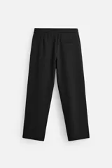 Pantalón negro de corte regular, confeccionado en tejido con viscosa, con cintura elástica, bolsillos frontales y trasero de vivo.