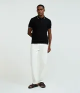 Remera polo blanca de media malla texturizada a rayas, corte regular, con cuello y mangas cortas en ribana con detalle contrastante en negro.