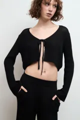 Cardigan de punto negro con diseño de escote en V y lazo frontal, confeccionado en algodón.