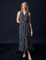 Vestido largo Donna Ricco de gasa color negro con estampado de lunares blancos, escote en V cruzado, sin mangas, cintura con lazo de ajuste y forro interno.