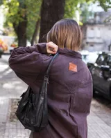 Camisa violeta oscuro con bolsillos con tapa ondulada y puños tableados.