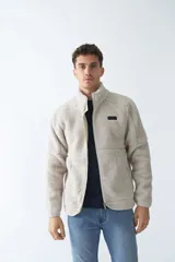 Campera de sherpa verde militar con cierre frontal y bolsillos laterales con cierre.