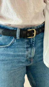 Cinturón de jean con hebilla dorada.